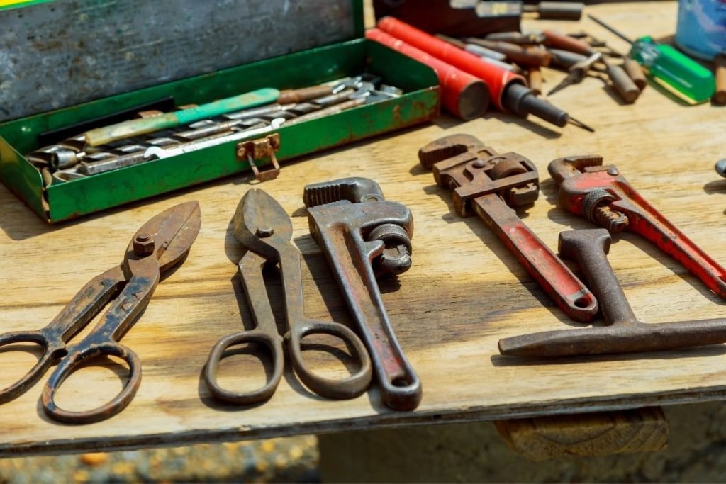 A table filled with different tools, including drills, pliers, and screwdrivers, set up for a project or repair work.